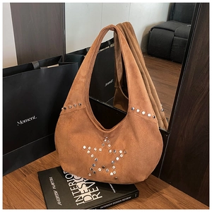 Detailed close-up of brown suede hobo bag featuring silver metal star rivet patterns