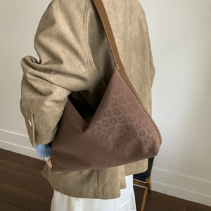 Brown leopard print shoulder bag in a retro geometric dumpling shape on a model