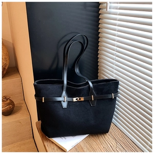 Detail of black suede tote bag featuring slim leather straps and golden metal twist lock