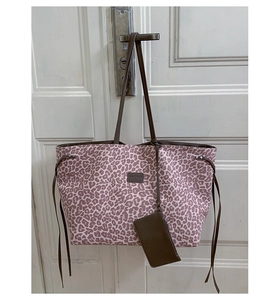 Détail du sac cabas imprimé léopard violet avec des bretelles en cuir marron