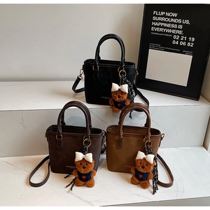 Detailed view of three vintage crossbody bucket bags in black, dark coffee and light brown