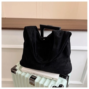 Close-up of minimalist black suede tote bag with soft texture and seamless strap design