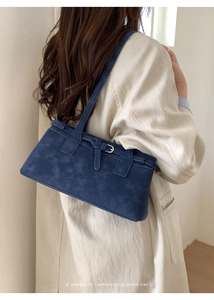 Nahaufnahme der minimalistischen blauen Wildleder-Schultertasche mit silbernen Schnallen