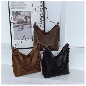 Detailed view of three vintage-style tote bags with woven chains on white steps