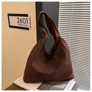 Macro shot of dark brown suede hobo tote bag with central vertical stitching detail