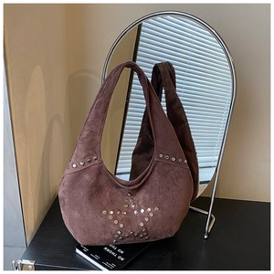 Detail of silver rivets star pattern on dark brown suede half-moon shoulder bag