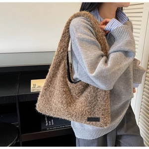 Gros plan du sac hobo en fausse fourrure marron avec logo noir et texture douce