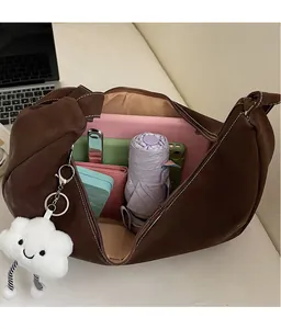 Spacious brown crescent hobo bag filled with daily essentials and cute charm