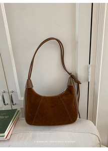 Detailed macro of caramel brown suede hobo bag with unique double leather cord strap knots