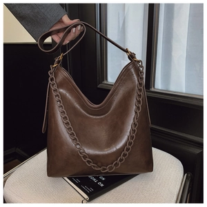 Detail of dark brown tote bag featuring vintage oil wax texture and chunky resin chain