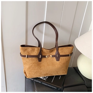 Macro detail of the caramel faux suede tote bag with golden metal buckle and leather handle