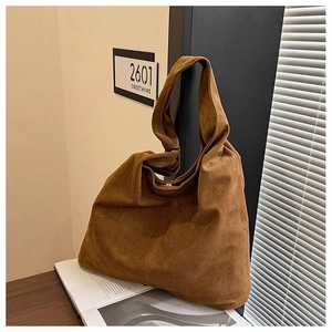 Detail of soft brown suede tote bag featuring a spacious interior and minimalist single strap