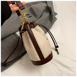Detail of faux fur bucket bag with brown leather drawstring and gold metal hardware
