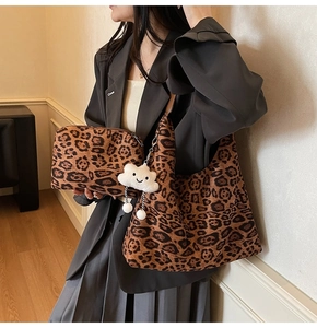 Leopard print hobo bag and pouch set with plush cloud charm shown on shoulder