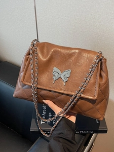 Sac en cuir marron avec fermoir papillon argenté et détails à motifs matelassés