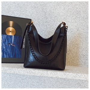 Detail of black vintage hobo bag with matte chain strap and adjustable shoulder band