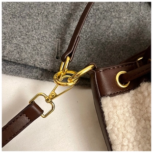 Detailed close-up of golden metal rings and lobster clasp on brown leather strap