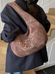 Brown suede hobo tote bag with silver star rivets shown on model shoulder