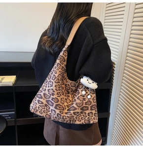 Detail view of large leopard print faux suede hobo bag with cute white cloud plush charm