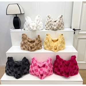 Close-up of plush checkerboard tote bags in seven colors on a minimalist display