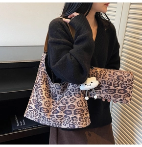 Detail of leopard print suede tote bag set with a plush cloud charm and clutch bag
