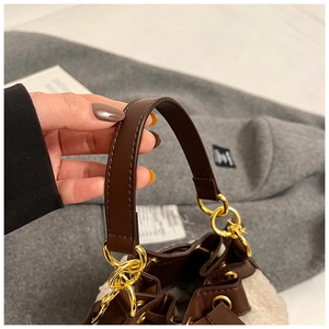 Detail of plush lamb wool bucket bag with premium brown leather strap and gold hardware