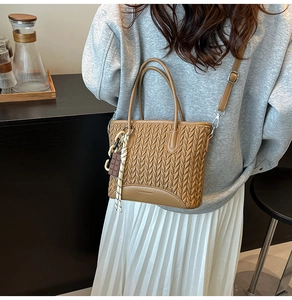 Detail of vintage brown woven bucket bag with chocolate charm and adjustable strap