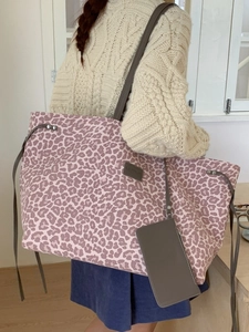 Grand sac cabas léopard avec pochette assortie et lanières grises porté par un mannequin