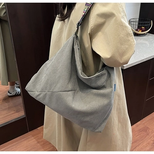 Detail view of grey corduroy hobo bag with colorful bohemian pattern strap