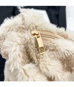 Detail of plush beige faux fur fabric with a premium gold metal zipper closure