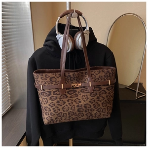 Detailed shot of large leopard print tote bag with premium gold lock and brown straps