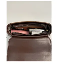 Detailed view of the striped lining and zippered compartment in the dark brown crossbody bag