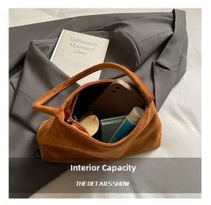 Macro view showing internal capacity of the brown suede handbag with daily essentials