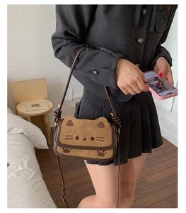 Detail of cute cat crossbody bag showing brown suede texture and embroidery details