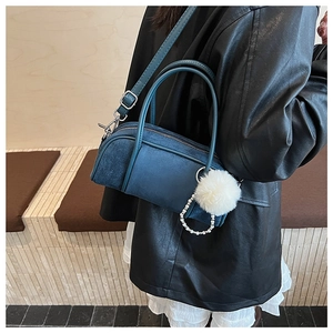 Navy blue cylindrical bowling bag in matte finish with plush ball and pearl charm