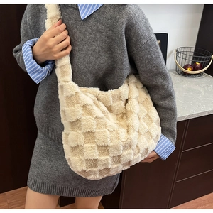 Detail of plush beige and white checkerboard texture on a large crossbody tote bag