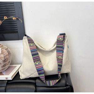 Detail of cream corduroy tote bag featuring a bohemian colorful printed wide strap