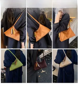 Detail of minimalist suede triangle shoulder bags with ethnic wooden bead tassels in four colors