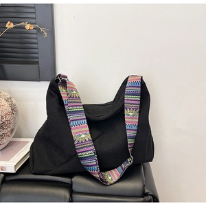 Detail of bohemian patterned strap on black corduroy tote bag in a lifestyle setting