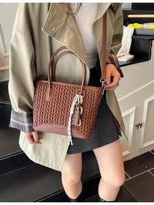 Brown woven pleated bucket bag with silk scarf and chocolate pendant for autumn fashion