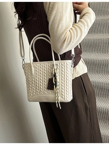 Chic beige woven tote bag with chocolate charm and crossbody strap for women