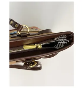 Detail of smooth gold zipper closure and striped lining on brown vintage tote bag