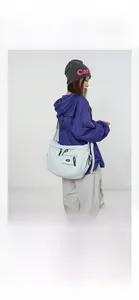 Détail d'un sac bandoulière en nylon bleu clair avec fermetures noires et poches style cargo