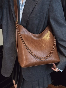 Classic brown leather hobo bucket bag with stylish chain detail for modern women