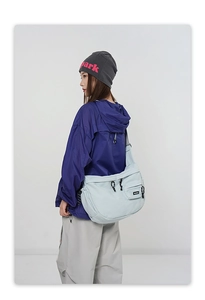 Détail d'un sac bandoulière en nylon bleu clair avec cordon de serrage et sangle réglable