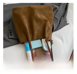 Internal capacity of brown matte tote bag showing laptop, phone and cosmetics