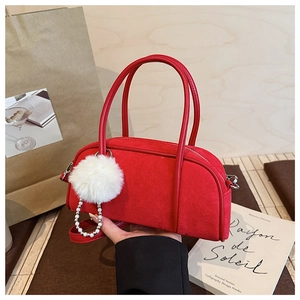 Detail of red suede Boston bag featuring a white fur pompom and pearl chain accessory