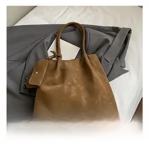 Close-up of brown frosted tote bag with matching small pouch and smooth matte texture