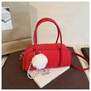 Detail of red suede bowling bag featuring soft texture and pearl fur ball charm