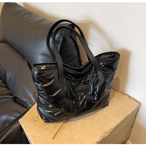 Gros plan du sac cabas matelassé noir avec étiquette de mode et texture brillante